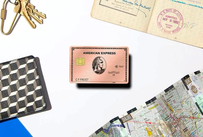 The Rose Gold American Express Card accompanied by travel accessories