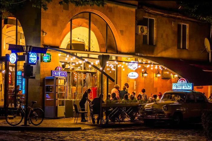 People enjoy the evening at an outdoor cafe in Yerevan, Armenia