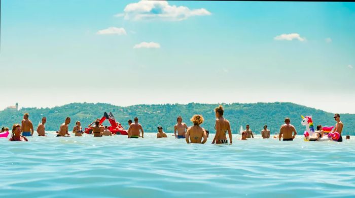 A group of swimmers enjoying the refreshing waters of a shimmering turquoise lake