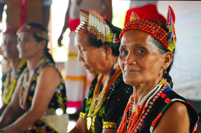 Murut woman in traditional attire adorned with colorful beads during a folklore festival in Sipitang, Sabah