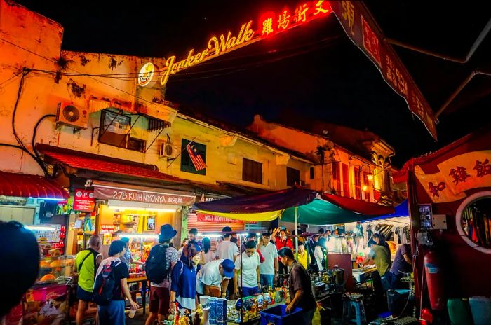 Visitors explore market stalls under the night sky on Jonker Walk in Chinatown.