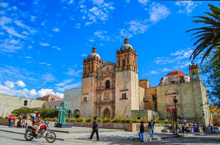 A bustling square by a church in Oaxaca filled with locals.