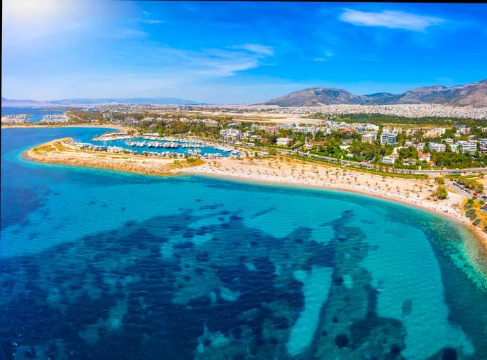 An aerial view of Glyfada Beach, part of the southern Athens Riviera, showcasing yacht marinas and crystal-clear waters, Greece