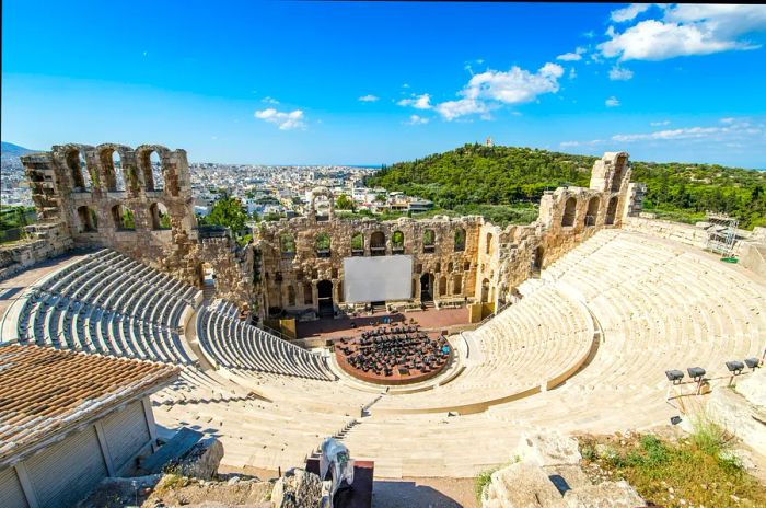 A sprawling ancient theater with seating arranged around a central stage