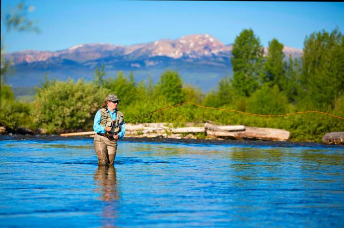 A woman fly fishes in a river in Montana