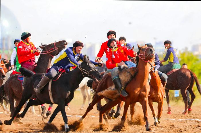 Two teams on horseback struggle over a furry headless goat carcass.