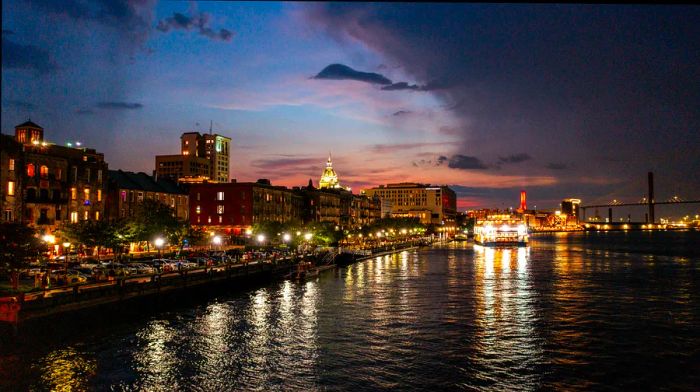 A picturesque view of the illuminated buildings along River St by the Savannah River at twilight, Savannah, Georgia.