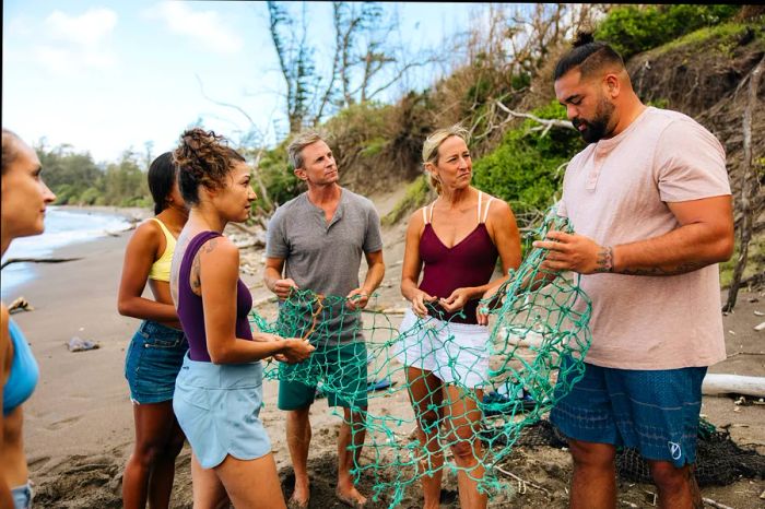 A guide teaches volunteer tourists about the dangers of discarded nets on beaches