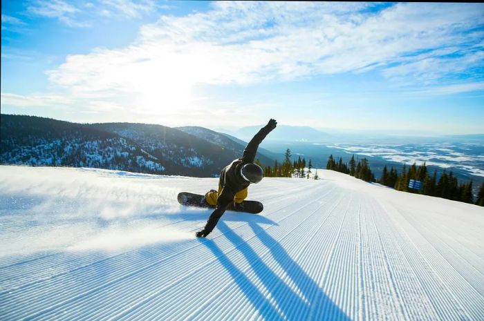 Snowboarder carving down a deserted slope in Montana.