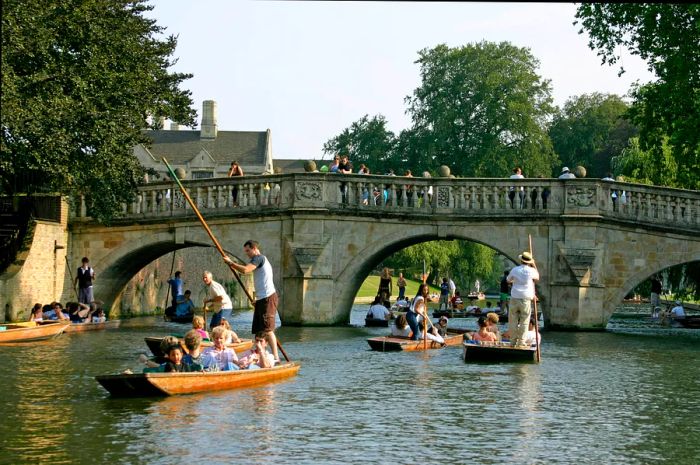 Punts gliding along the River Cam with people enjoying punting near King’s College, Cambridge, England