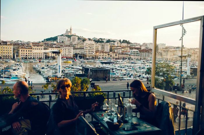 Two women enjoying the view from La Caravelle café overlooking the port in Marseille