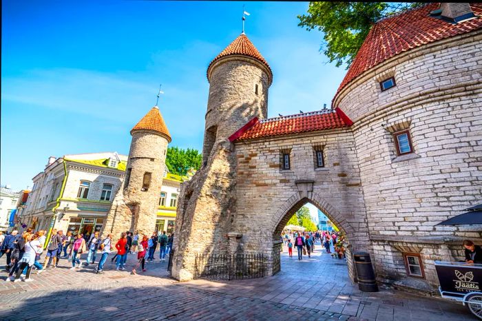 Tourists gather near the Old Town city walls at the bustling city gate.