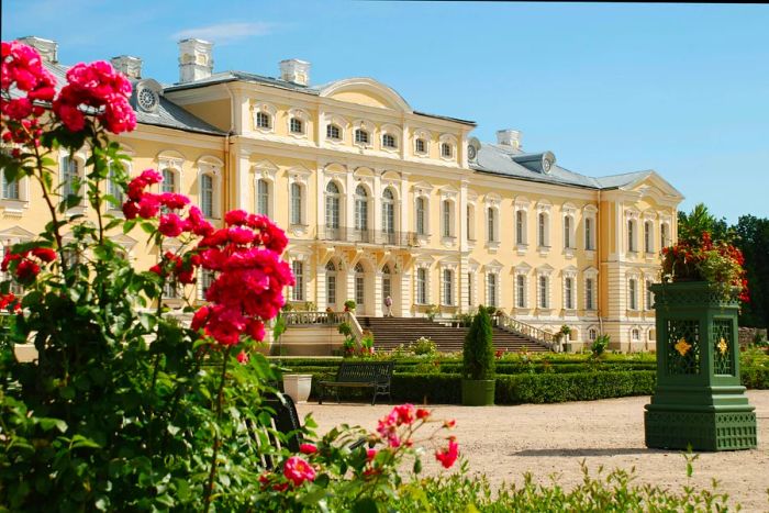 An exterior view of an extravagant palace surrounded by grand gardens