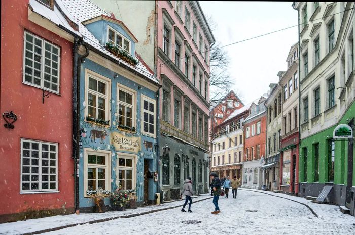 A snowy day in a pedestrian-friendly old town street surrounded by buildings