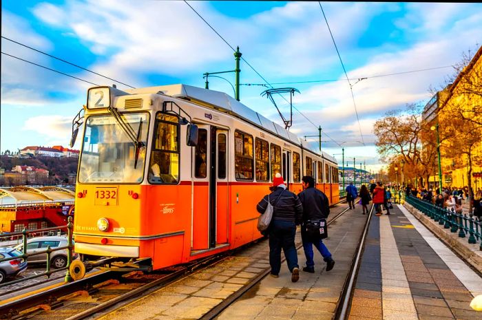 A yellow tram navigates the streets of Budapest.