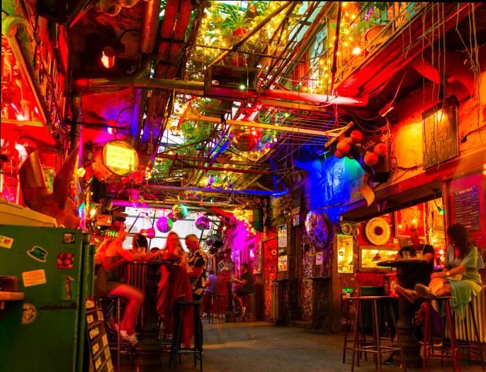 An evening bar scene with patrons seated on mismatched furniture