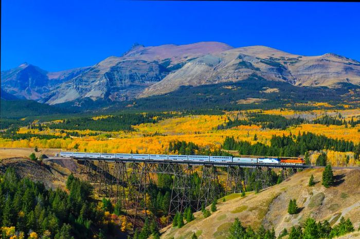 A train passenger crosses a trestle bridge in Glacier National Park