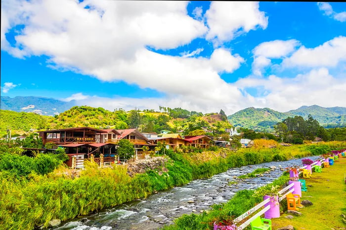 A river flows at the edge of a rural town.