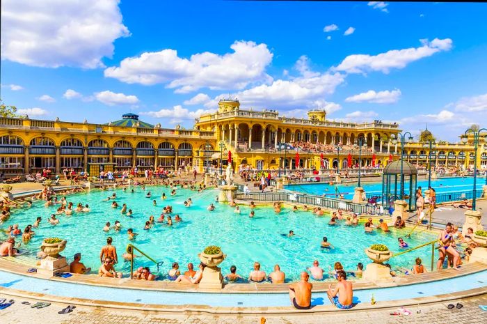 A large outdoor thermal spa pool teeming with people