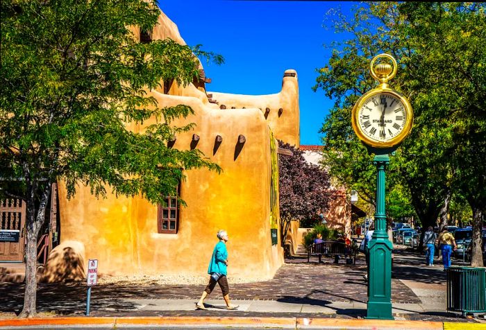 A woman strolls past a charming building in Santa Fe, New Mexico.