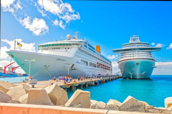 Cruise ships docked at the pier on the Dutch side of St. Maarten, with passengers strolling along the pier.