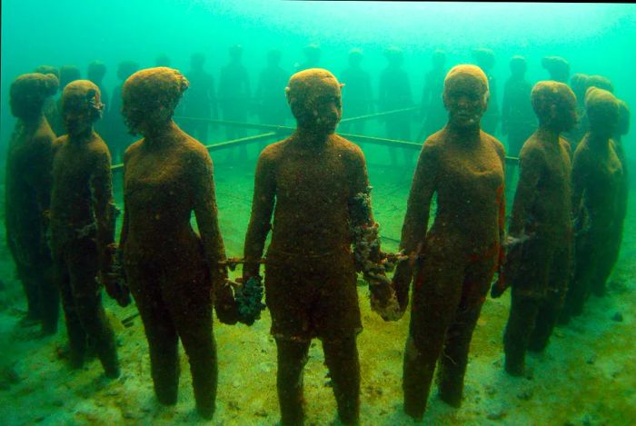 A circle of sculptures depicting people holding hands rests beneath the sea in Grenada.