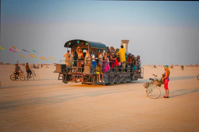 Participants in festive vehicles and on bicycles at the Burning Man festival, Black Rock Desert, Nevada, USA