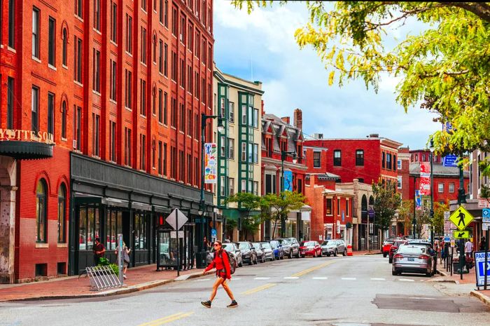 A woman strolls across a street in downtown Portland, Maine, USA