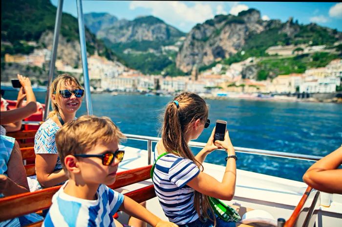 Travelers enjoying a ferry ride near the iconic city of Amalfi, Campania, Italy