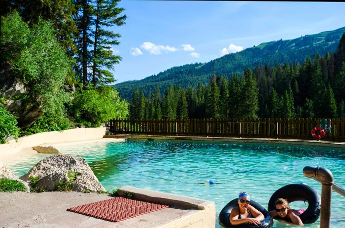 Two women floating in black rubber rings in a hot springs-fed artificial pool in Wyoming