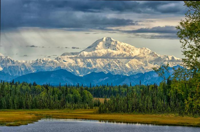 A towering snow-capped mountain looms over the landscape.