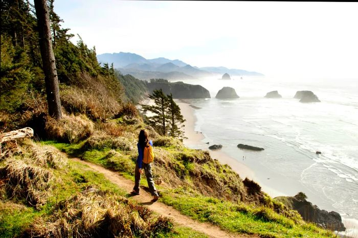 A woman hiking a secluded path along the coastline.