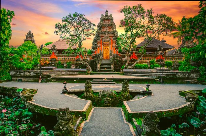 A path lined with lotus-flower ponds leads to a pale red temple.