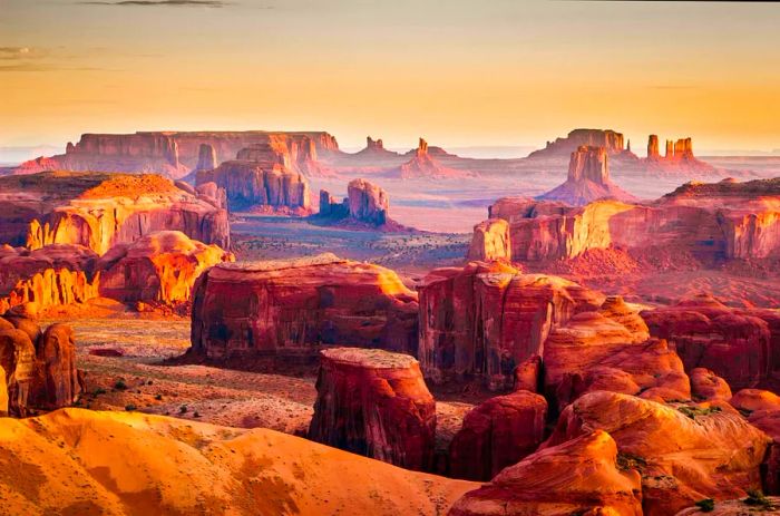 Towering red-hued stacked rocks and outcrops in a desert setting.