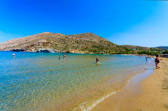 Galissas Beach in Syros, Greece, framed by a clear blue sky. Galissas is one of the few sandy beaches on the island.