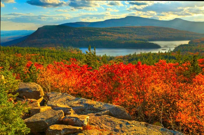 Afternoon sunlight streaming onto Sunset Rock in autumn, offering a view over North-South Lake in the Catskills Mountains of New York.