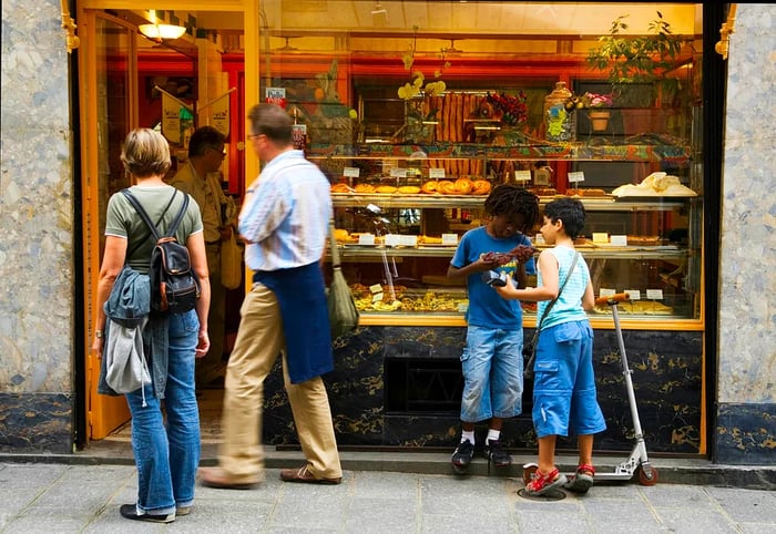 People gazing at a bakery display in France