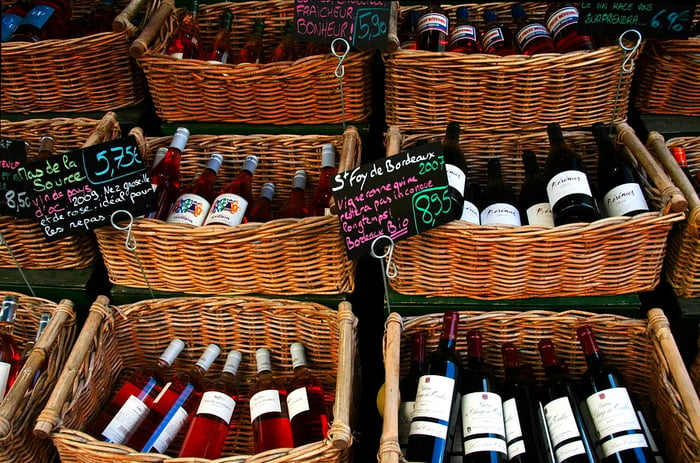 An aerial view of wine bottles nestled in baskets at a French wine shop