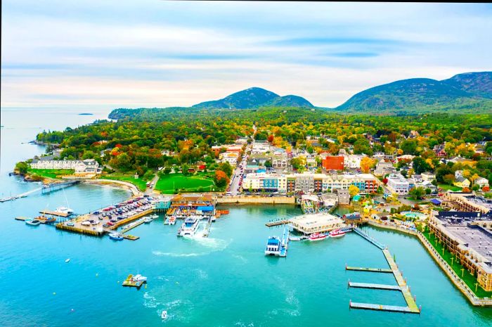 An aerial view of a coastal town featuring a quaint harbor