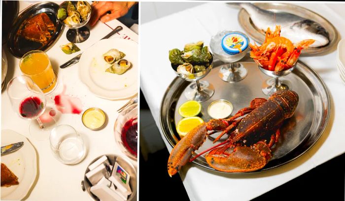 Lobster, canned fish, wine, and napkins adorned with lipstick on a white tablecloth