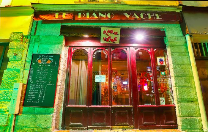 A view of the classic French cafe, Le Piano Vache, lit up at night