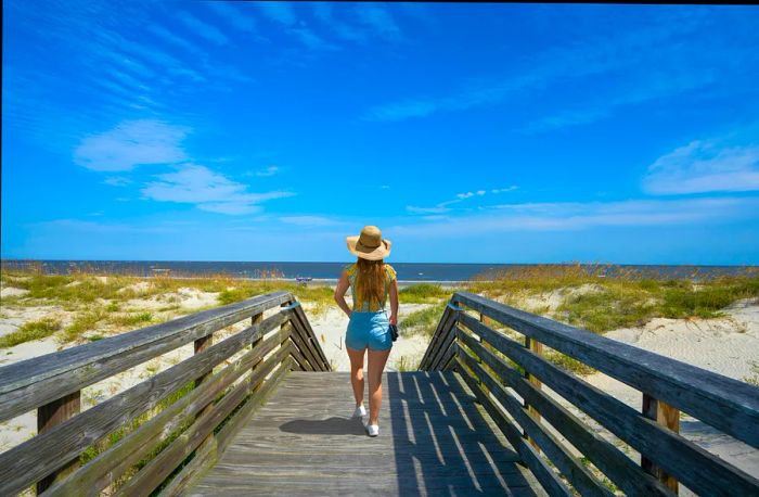 A girl walking along the boardwalk to the beach on Jekyll Island, Georgia