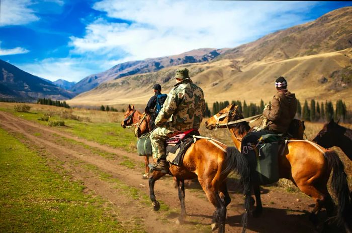 Riders on horseback traversing the mountains of Kazakhstan