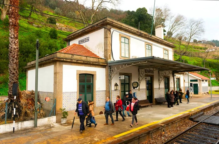 A quaint small rural station with passengers moving along the platform