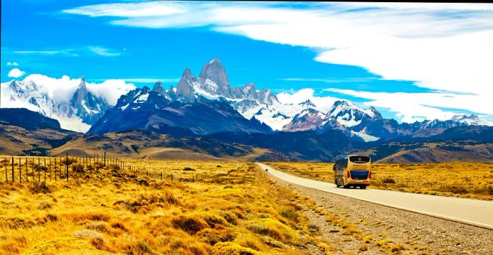 A bus makes its way along the road to El Chaltén, surrounded by breathtaking mountain scenery