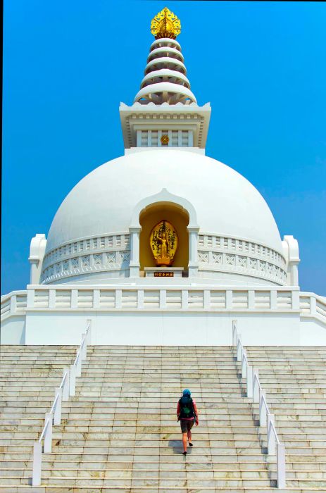 A view of the World Peace Pagoda in Lumbini, with a person ascending the stairs.