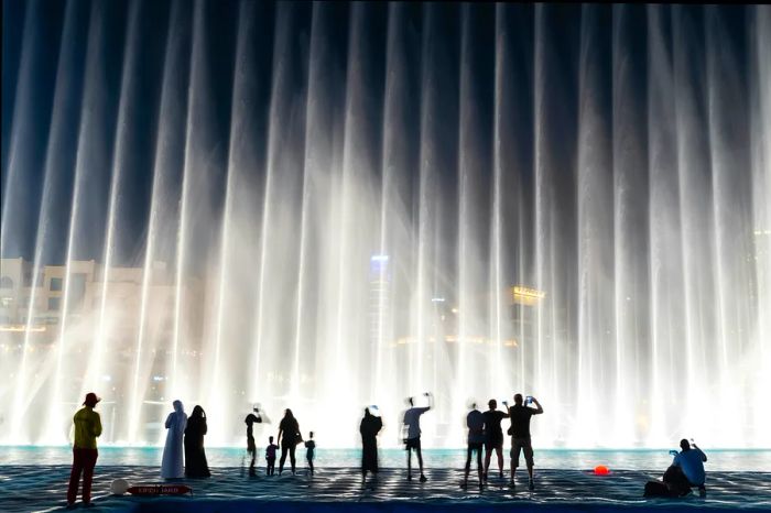 The stunning view of people enjoying the fountain show in Dubai at night, UAE