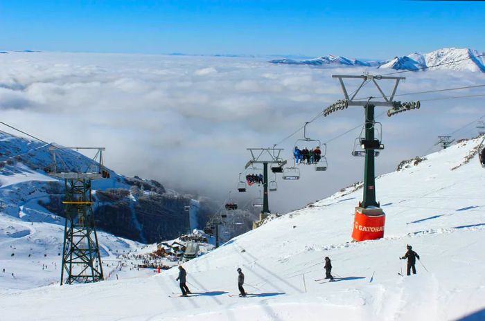 Skiers enjoy the thrill of skiing above the clouds at a ski resort.