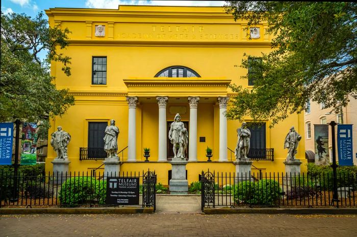 The exterior of the historic yellow Telfair Academy, a stunning mansion and museum.