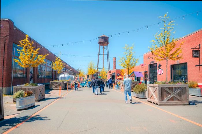 Visitors stroll through an open-air retail area featuring a prominent water tower at one end